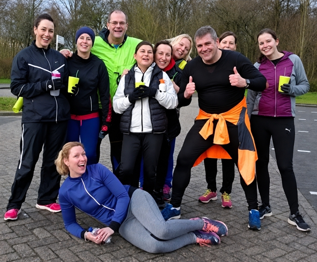 Lachende groep deelnemers met sportdrank na de training